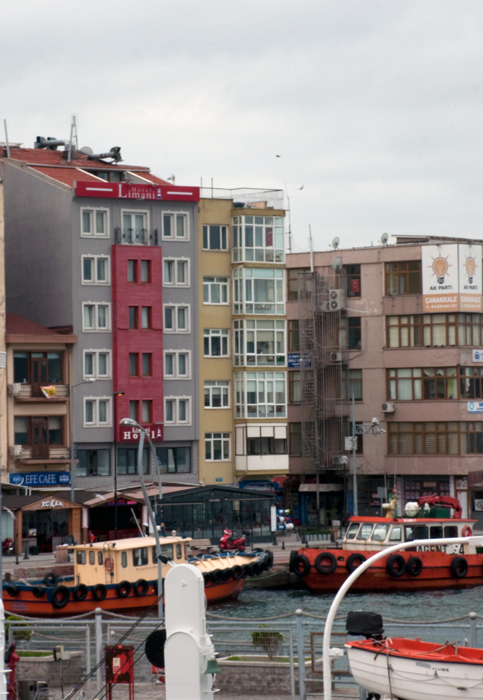 Limanı Oteli is the grey and red building overlooking the working harbor.