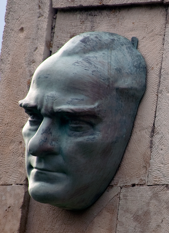 A strange protruding sculpting of Atatürk's head at Anzac Cove.  His 1934 statement:  THOSE HEROES THAT SHED THEIR BLOOD, AND LOST THEIR LIVES ... YOU ARE NOW LYING IN THE SOIL OF A FRIENDLY COUNTRY. THEREFORE, REST IN PEACE. THERE IS NO DIFFERENCE BETWEEN THE JOHNNIES AND THE MEHMETS TO US WHERE THEY LIE SIDE BY SIDE, HERE IN THIS COUNTRY OF OURS … YOU, THE MOTHERS, WHO SENT THEIR SONS FROM FAR AWAY COUNTRIES ... WIPE AWAY YOUR TEARS. YOUR SONS ARE NOW LYING IN OUR BOSOM AND ARE IN PEACE. AFTER HAVING LOST THEIR LIVES ON THIS LAND, THEY HAVE BECOME OUR SONS AS WELL. ...is inscribed on the large stone monument included with this head.